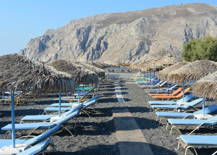 Plaża Kamari z czarnym piaskiem, leżaki
